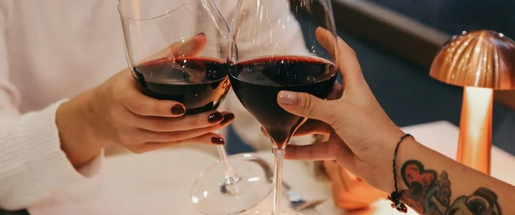 Brindis con copas de vino en una cena romántica por el Día de los enamorados en un restaurante
