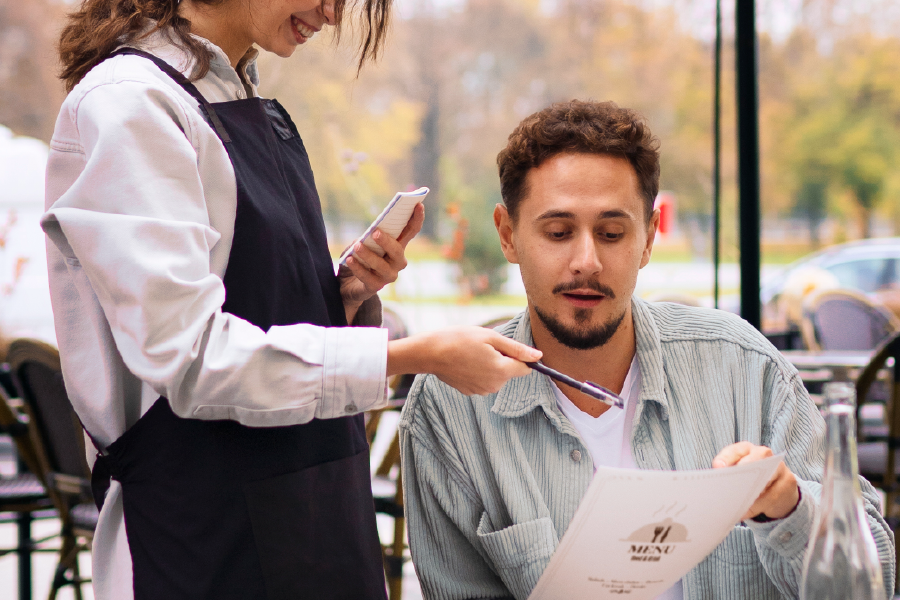 Cliente evaluando el menú en un negocio gastronómico como parte de su experiencia en el local