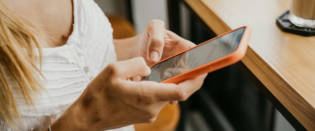 Cliente usando el celular en una mesa del restaurante para comunicarse o hacer una reserva